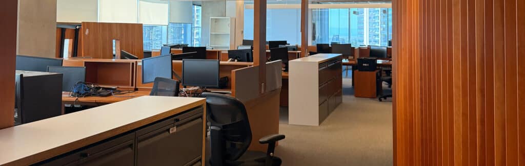 BBX Moving | Office Movers – Burnaby - Open office space in Richmond with empty desks, chairs, computers, and wooden partitions, illuminated by natural light from large windows—ideal for Office Movers planning a seamless transition. Open office space in Richmond with empty desks, chairs, computers, and wooden partitions, illuminated by natural light from large windows—ideal for Office Movers planning a seamless transition.