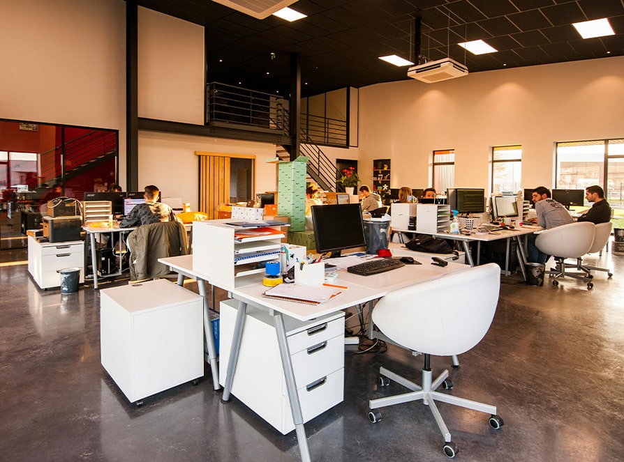 BBX Moving | Office Movers – Burnaby - Modern open plan Richmond office with white desks, computers, and people working; large windows provide natural light and a mezzanine is visible in the background—ideal for teams or those seeking Office Movers solutions. Modern open plan Richmond office with white desks, computers, and people working; large windows provide natural light and a mezzanine is visible in the background—ideal for teams or those seeking Office Movers solutions.
