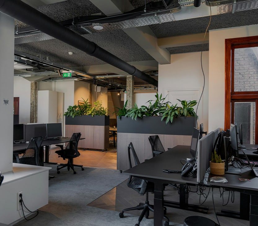 BBX Moving | Office Movers – Burnaby - Modern open plan office in Richmond with vacant desks, black chairs, computer monitors, and planters dividing workspaces; large windows and exposed ceiling pipes are visible—perfect for Office Movers seeking spacious environments. Modern open plan office in Richmond with vacant desks, black chairs, computer monitors, and planters dividing workspaces; large windows and exposed ceiling pipes are visible—perfect for Office Movers seeking spacious environments.